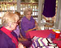 Christy, Helen, and Joy admiring the sweater that Christy is knitting.